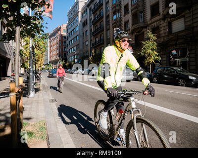 Barcelona, Spanien - 12 Nov, 2017: Senior paar Radfahren im Zentrum von Barcelona am frühen Morgen Helme tragen Stockfoto
