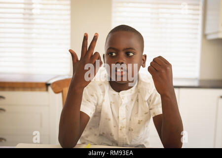 African American Boy Hausaufgaben am Esstisch in der Küche Stockfoto