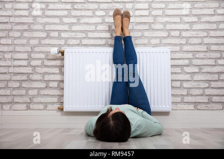 Nahaufnahme einer Frau Erwärmen ihre Füße auf weißen Kühler zu Hause Stockfoto