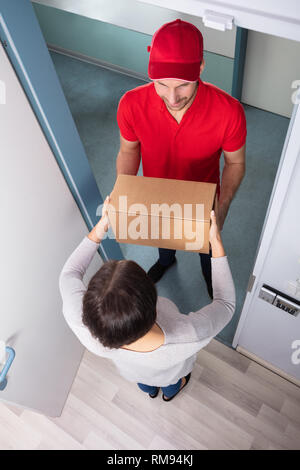 Nahaufnahme der Frau unter Karton ab Lieferung Mann Stockfoto