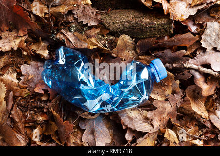 Noch immer leben eines leeren verwendete Kunststoff Flasche Abfälle auf waldboden als Umweltverschmutzung closeup Stockfoto