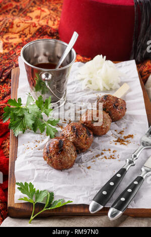 Rindfleisch Döner mit Soße. Traditionelle orientalische, Arabische und mediterrane Speisen. Türkischer hut Fez oder Tarboosh im Hintergrund. Stockfoto