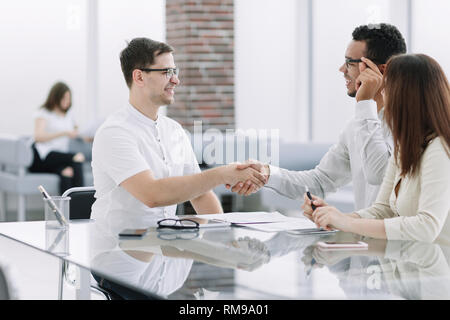 Lächelnd Geschäftspartner Händeschütteln während der Sitzung Stockfoto