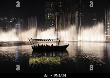 Touristen beobachten die Dubai Fountain Show von einem traditionellen Boot, Dubai, Vereinigte Arabische Emirate. Stockfoto