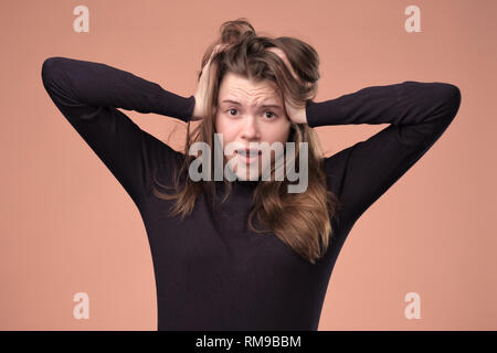 Hübsches Mädchen schrie in Panik auf Braun baclground. Stockfoto