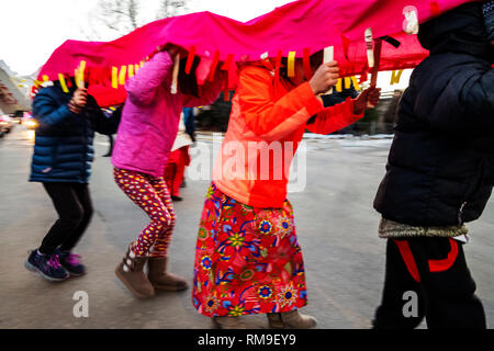 Pan blur motion Bild der Kinder tanzen in ausgefallenen Kostümen an der Salida 3. jährliche Lunar New Year Parade. Das Jahr des Schweins. Stockfoto