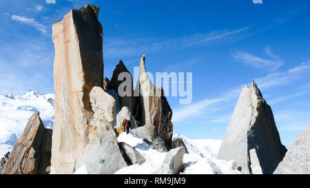 Bergführer und einem männlichen Klienten auf einem Felsen und Snow Ridge in Richtung hoher Gipfel in den französischen Alpen in der Nähe von Chamonix. Stockfoto