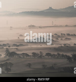 Marshwood Vale, Dorset, Großbritannien. 14. Februar 2019. UK Wetter: Am frühen Morgen Nebel steigt aus den Bereichen Marshwood Vale auf der Suche nach kultigen Colmers Hügel in der Ferne. Credit: Celia McMahon/Alamy leben Nachrichten