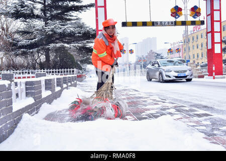 Shijiazhuang, Provinz Hebei Provinz Chinas. 14 Feb, 2019. Eine Abwasserentsorgung Arbeiter fegt Schnee auf der Straße in der Stadt Xinle, nördlich der chinesischen Provinz Hebei, 14.02.2019. Credit: Jia Minjie/Xinhua/Alamy leben Nachrichten Stockfoto