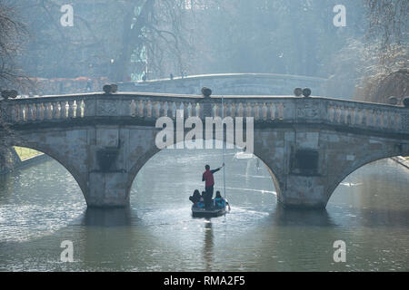 Cambridge England UK. 14. Februar 2019. Am frühen Morgen Stochernd auf der Cam. Als für die Jahreszeit ungewöhnlich hohen Temperaturen 12 Grad Februar in Ostengland, Besucher der Universitätsstadt Cambridge erreichen genießen Sie am frühen Morgen stochern auf dem Fluss Cam hier gesehen vorbei unter dem historischen Clare Brücke im Jahre 1640 erbaut, als die Sonne verbrennt die Morgennebel. Credit: Brian Harris/Alamy leben Nachrichten Stockfoto