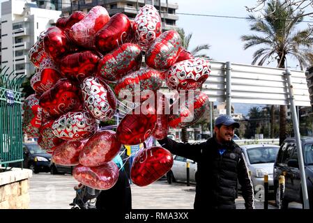 Beirut, Libanon. 14 Feb, 2019. Ein Mann verkauft, herzförmige Luftballons auf einer Straße während der Valentinstag in Beirut, Libanon, am 14.02.2019. Credit: Bilal Jawich/Xinhua/Alamy leben Nachrichten Stockfoto