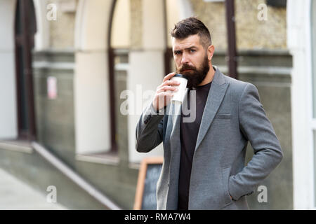 Geschäftsmann lumbersexual Erscheinungsbild genießen Sie Kaffee Pause aus Business Center. Entspannen und erholen Sie sich. Man bärtige hipster Pappbecher Kaffee trinken. Noch ein Schluck Kaffee. Kaffee trinken für Unterwegs. Stockfoto