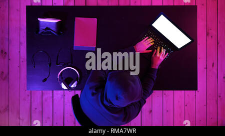 Cyberkriminalität, Hacking und Technologie Konzept - männliche Hacker in dunklen Zimmer Code schreiben oder über Computer Virus Programm für Cyber Attack. Weißes Display. Stockfoto