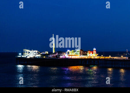 Brighton, Großbritannien - Juni 2018 Vista Palace Pier von Brighton East Sussex United Kingdom in der Nacht. Licht reflektieren und die Regenbogenfarben auf Blau Stockfoto