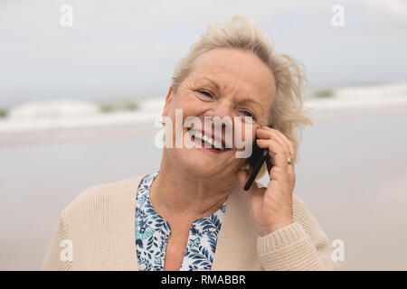 Gerne ältere Frau Gespräch am Handy am Strand Stockfoto