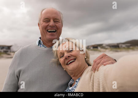Gerne älteres Paar Spaß am Strand Stockfoto