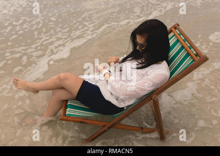 Junge Frau relaxen im Liegestuhl und mit der Zukunft Stockfoto