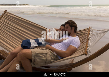 Junges Paar entspannen auf der Hängematte am Strand Stockfoto