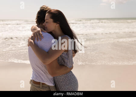 Romantische junge Paare einander umarmen am Strand Stockfoto