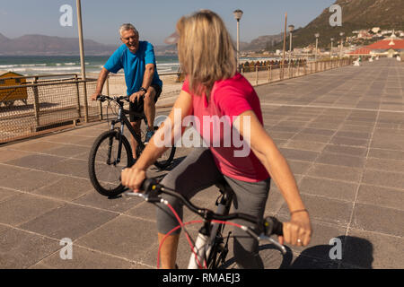 Senior paar Fahrrad auf einer Promenade am Strand Stockfoto