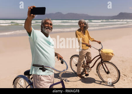 Älteres Ehepaar miteinander reden selfie mit Handy am Strand Stockfoto