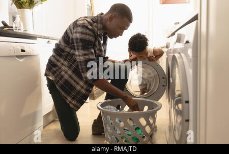 Vater und Sohn Wäsche waschen in der Waschmaschine Stockfoto