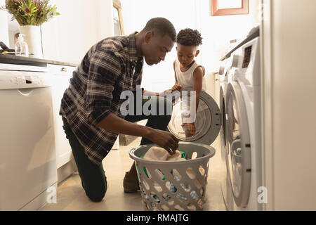 Vater und Sohn Wäsche waschen in der Waschmaschine Stockfoto