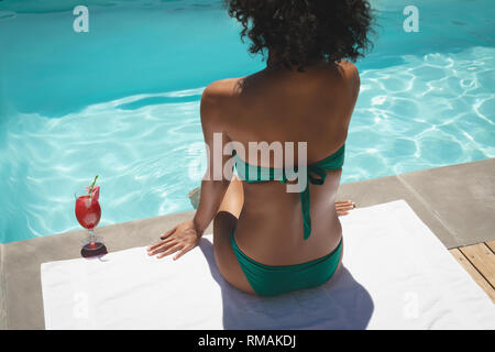 Junge afrikanische amerikanische Frau am Pool sitzen in Ihrem Hinterhof Stockfoto