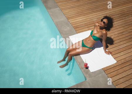 Junge afrikanische amerikanische Frau am Pool sitzen in Ihrem Hinterhof Stockfoto