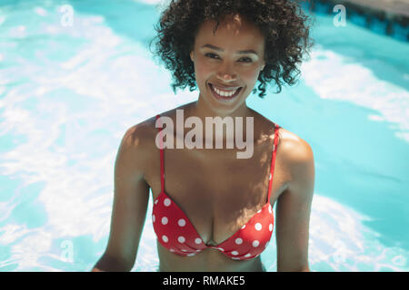 Glückliche junge afrikanische amerikanische Mann an der Kamera schaut im Pool Stockfoto