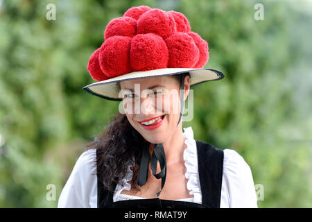 Das Portrait einer schönen Frau, die traditionelle Kleidung und ein Bollenhut ihre Zähne zu lecken. Stockfoto