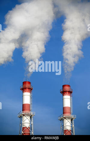 Zwei gestreifte rote und weiße Industrie Rohre mit weisser Rauch über den wolkenlosen blauen Himmel. Vorderansicht closeup Stockfoto