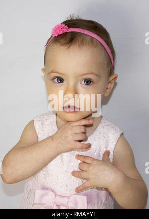 Sehr süße 20 Monate alten Baby Portrait. Schöne 1 Jahr altes Kleinkind Mädchen, natürlich posieren. Kleine Mädchen, das Tragen von niedlichen rosa Kleid und Kopfband. Stockfoto