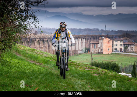 LUCCA, Italien - 12. JUNI 2009: Unbekannter Radfahrer radeln in Aquädukt bei Guamo, in der Nähe von Lucca, Toskana, Italien, gebaut von Lorenzo Nottolini 1823 Stockfoto