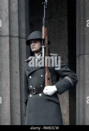 Schutz der Nationalen Volksarmee (NVA) der DDR mit Gewehr vor der Neuen Wache auf dem Boulevard Unter den Linden in Ost-Berlin. Stockfoto