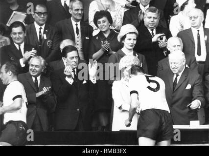 Königin Elisabeth II. gratuliert der Deutschen Nationalmannschaft auf den WM-Titel bei der WM in England: links Uwe Seeler, rechts Willi Schulz. Stockfoto