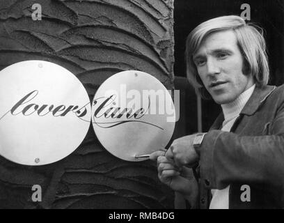 Fußballer Günter Netzer öffnet seine eigene Bar namens 'Lovers Lane' an der Waldhausener Straße 55 in Mönchengladbach. Die Fassade der Nachtclub ist dekoriert in Schwarz und die Seitenwände der Innenraum sind mit Aluminiumblechen abgedeckt. Das Bild zeigt die Netzer Befestigen des Türblatts. Stockfoto