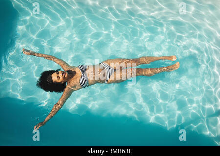 Junge mixed-race Frau Schwimmen im Pool Stockfoto