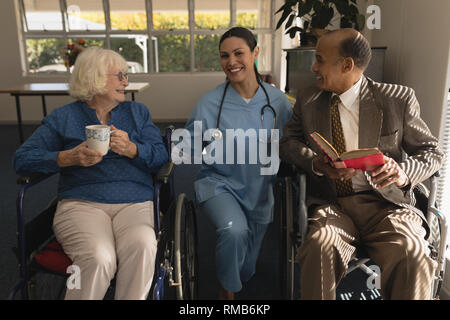 Vorderansicht des weiblichen Arzt im Gespräch mit dem Senior Paar zu Hause deaktivieren Stockfoto