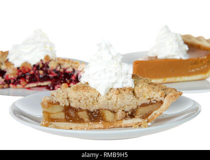 Nahaufnahme auf Apfel, Kirsche und Pumpkin Pie Slices auf einzelne Platten mit Schlagsahne oben auf Ihnen, isoliert auf Weiss. Fokus auf der Torte, Apple. Stockfoto