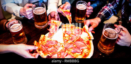 Freunde mit Bierkrug und Pizza in der Bar Stockfoto