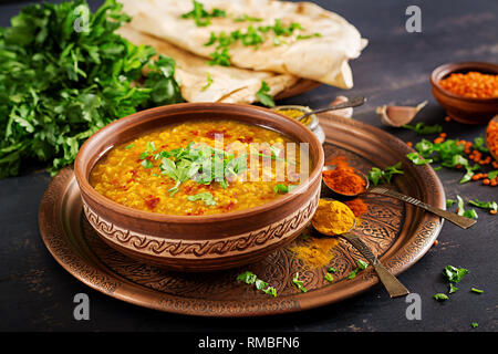 Indisches Dal. Traditionelle indische Suppe Linsen. Indische Dhal spicy Curry in der Schüssel, Gewürze, Kräuter, rustikale schwarz Holz- Hintergrund. Authentische indische Gericht. O Stockfoto