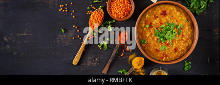 Indisches Dal. Essen. Traditionelle indische Suppe Linsen. Indische Dhal spicy Curry in der Schüssel, Gewürze, Kräuter, rustikale schwarz Holz- Hintergrund. Ansicht von oben. Authenti Stockfoto