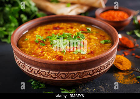 Indisches Dal. Traditionelle indische Suppe Linsen. Indische Dhal spicy Curry in der Schüssel, Gewürze, Kräuter, rustikale schwarz Holz- Hintergrund. Authentische indische Gericht. O Stockfoto
