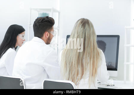 Ansicht der Rückseite. Eine Gruppe von Wissenschaftlern am computer monitor Stockfoto