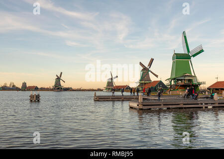 Malerische typisch Herbst holländische Windmühle Landschaft mit einer Reihe verschiedenster Art der Windmühlen am Fluss Ufer während des Tages mit einer intensiven blauen Himmel Stockfoto