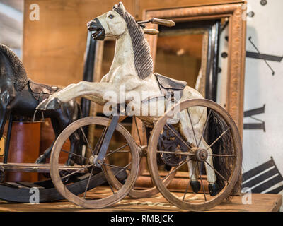 Antike hölzerne Spiel: Schaukelpferd mit drei Rädern. Stockfoto