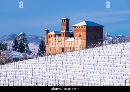 Blick auf das Schloss von Grinzane Cavour, Unesco Gebiet, und die schneebedeckten Weinberg, der Himmel ist blau Stockfoto