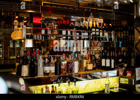 Vorderansicht des hinter der Theke in einem Restaurant. Es gibt Flaschen Wein und verschiedenen Geistern in den Regalen. Stockfoto