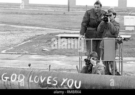 Mitglieder der DDR-Grenztruppen beobachten und dokumentieren einer Bereitstellung der West-Berliner Polizei gegen die Insassen des sogenannten Lenne Dreiecke am Potsdamer Platz. Ende Mai 1988, mehrere hundert Personen besetzt ein Standort in unmittelbarer Nähe der Mauer gegen den Bau einer Autobahn zu protestieren. In der Folge gab es immer wieder Konflikte mit der Polizei. Stockfoto
